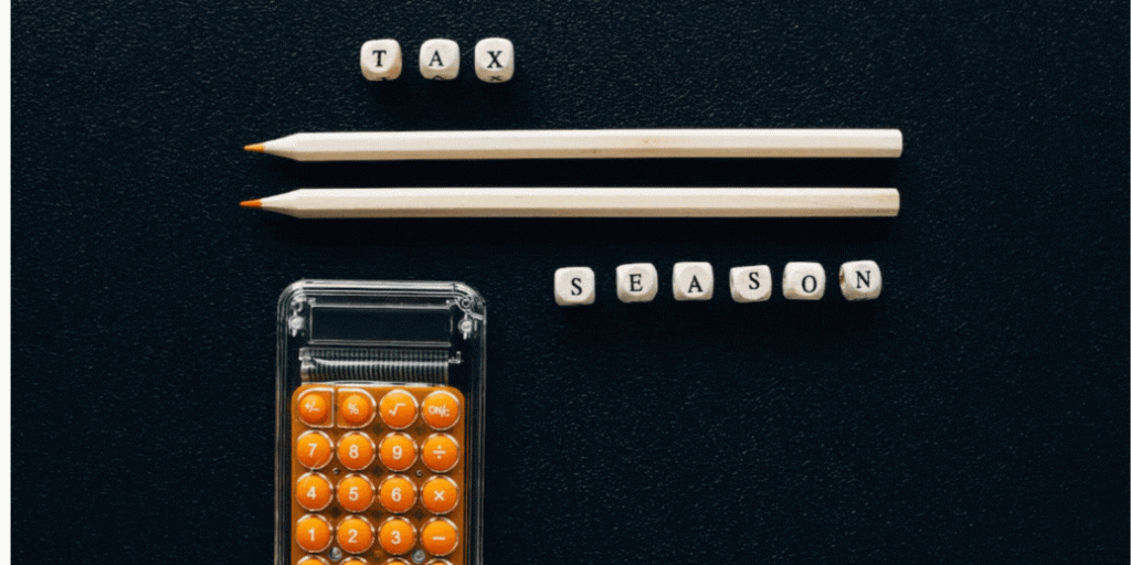 two pencils, a pocket calculator with orange buttons and nine beads spelling 'tax season' alongside a box with the name of the blog title